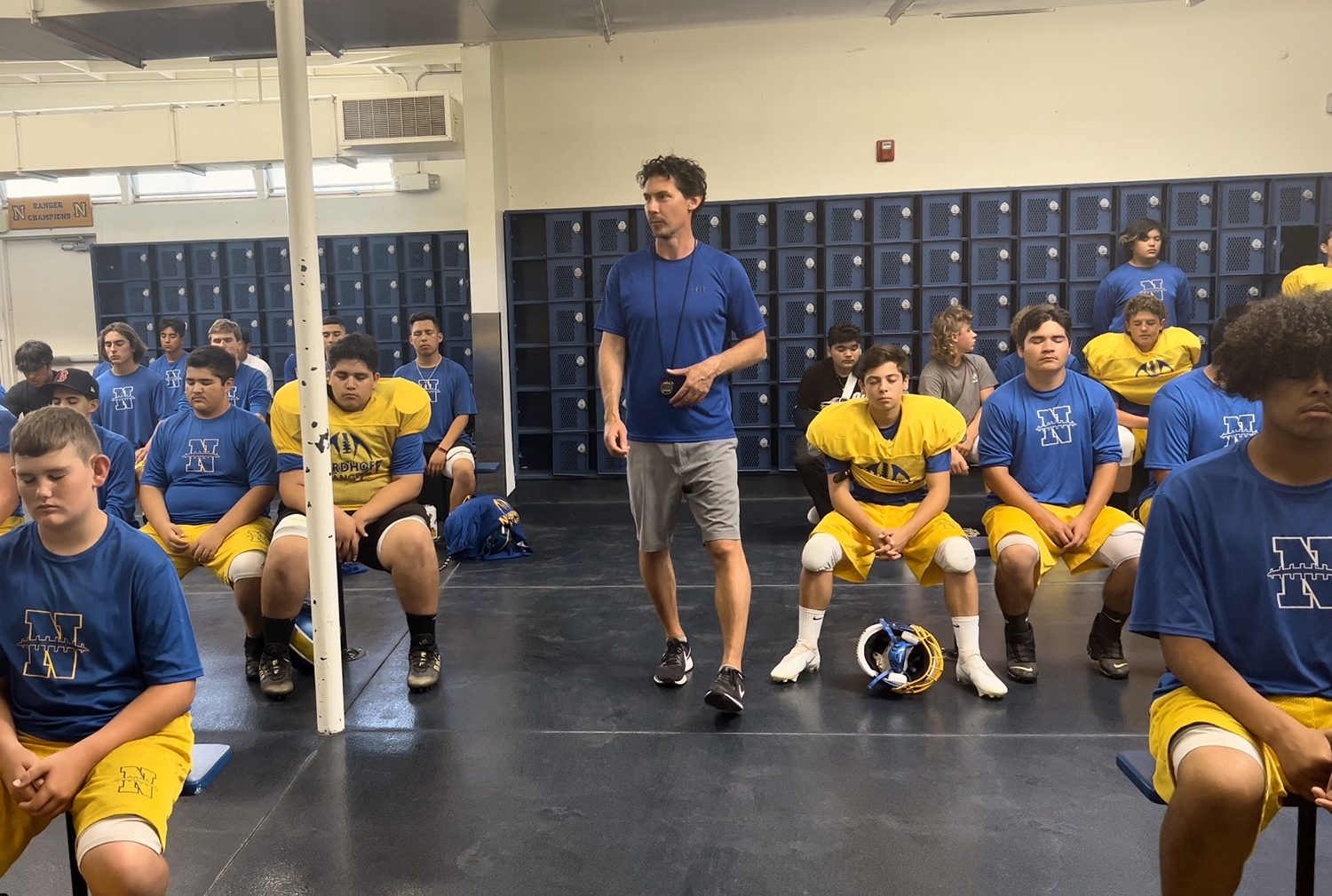 Jeremy in the locker room coaching a highschool football team